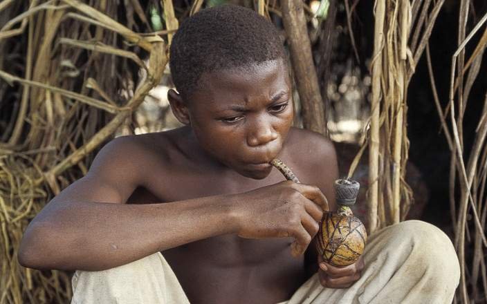 A boy in Batwa tribe drinking 