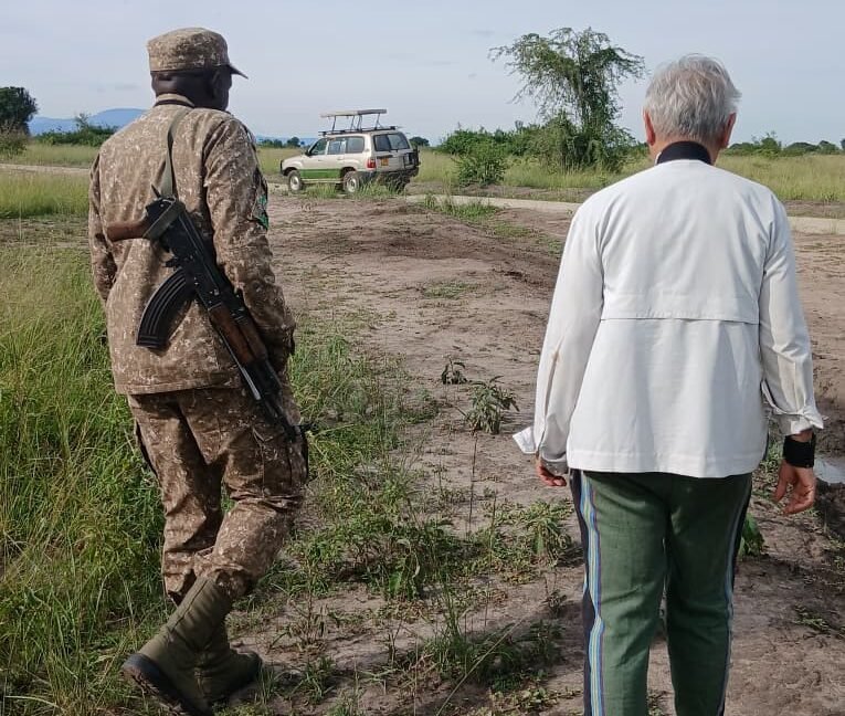tourist walking with a Ugandan tourist ranger 